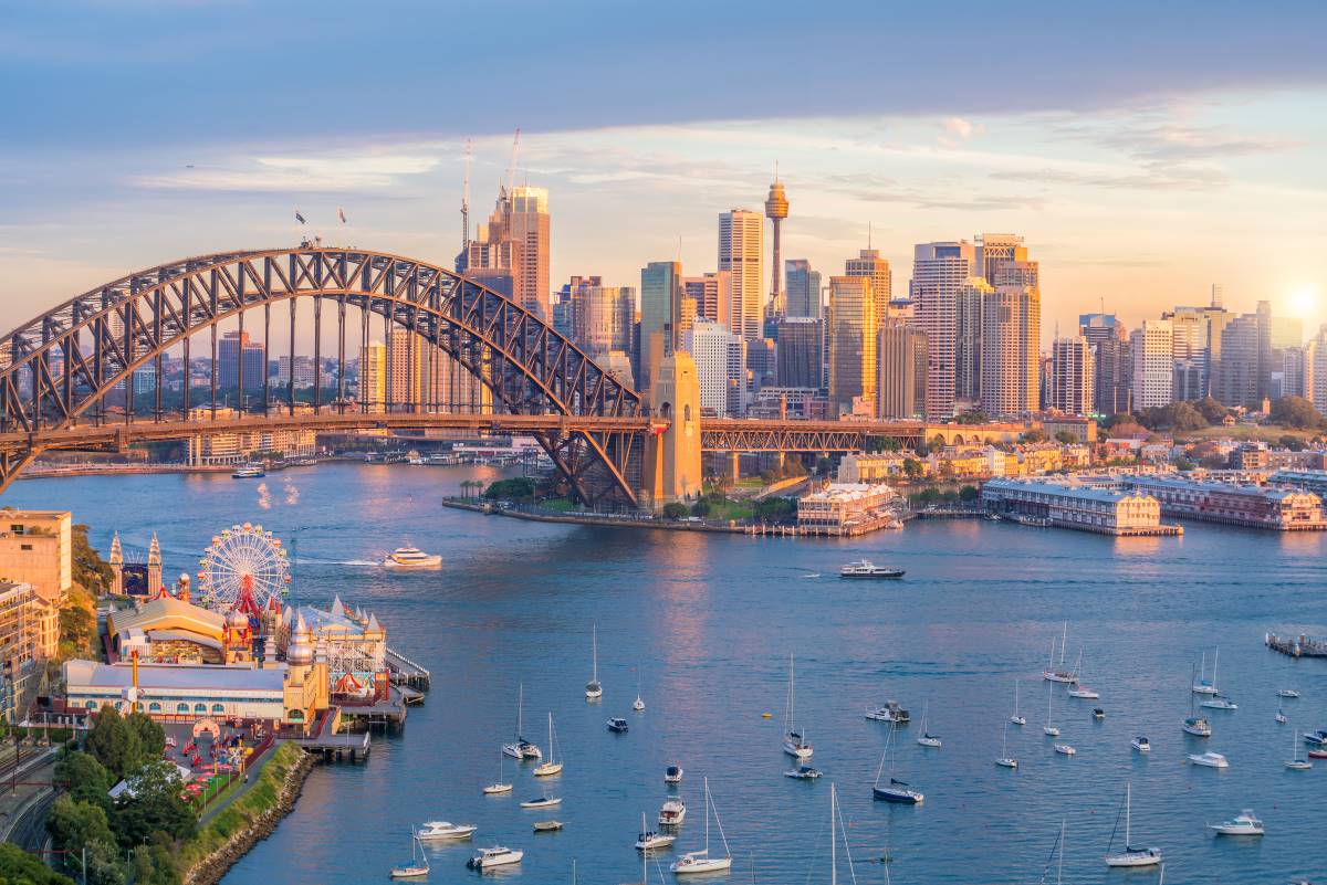 Vista hipnotizante do pôr do sol com a Ponte da Baía de Sydney e a linha do horizonte da cidade, uma cena a não perder para aqueles que exploram a beleza deste país notável com um visto Austrália.