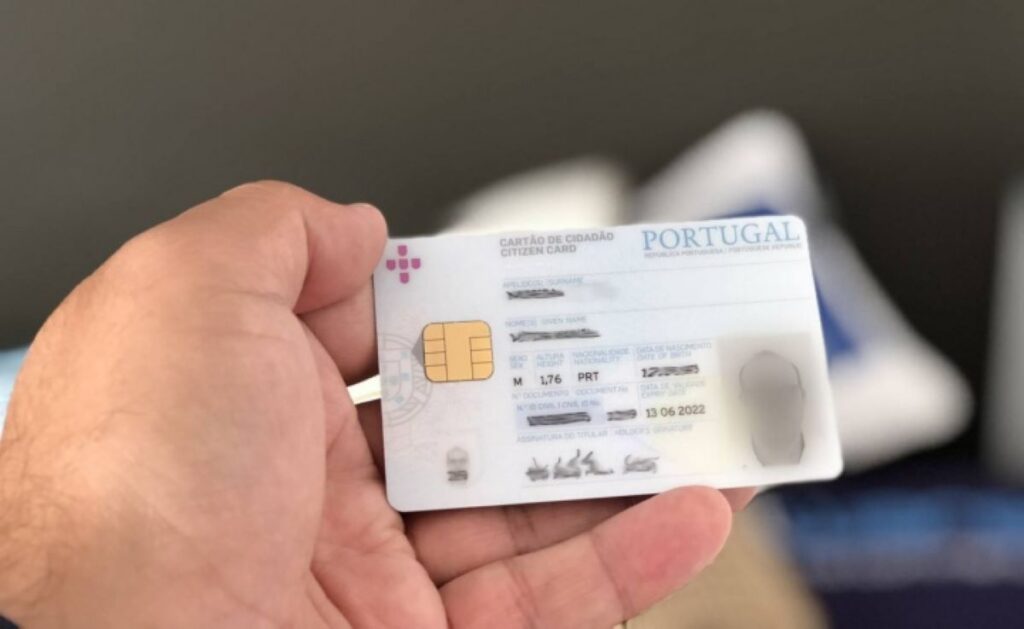 Mão segurando um Cartão de Cidadão português, documento essencial para obter o Número de Identificação Fiscal (NIF) em Portugal.