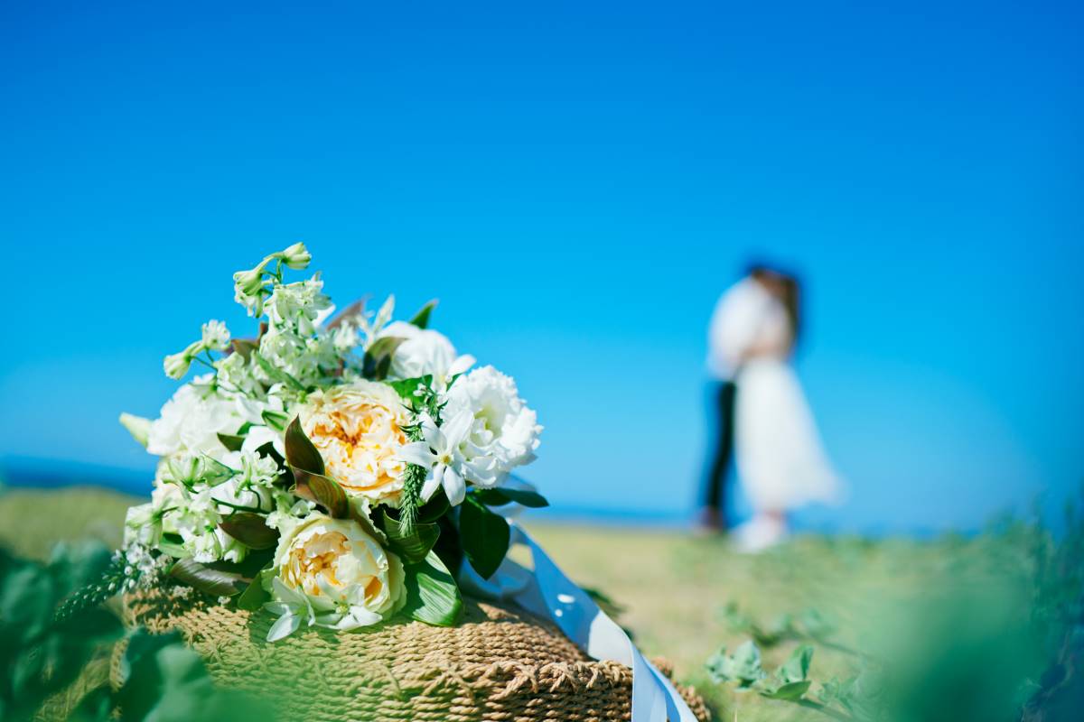 Imagem de um buquê de flores com um casal ao fundo, simbolizando a importância do registo do casamento no estrangeiro para garantir a legalidade e reconhecimento da união em Portugal.