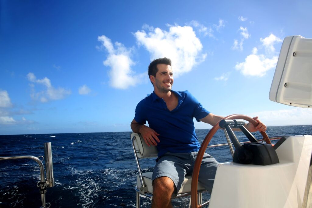 Homem a conduzir um barco, exemplificando a importância de ter uma licença de condução de embarcações.