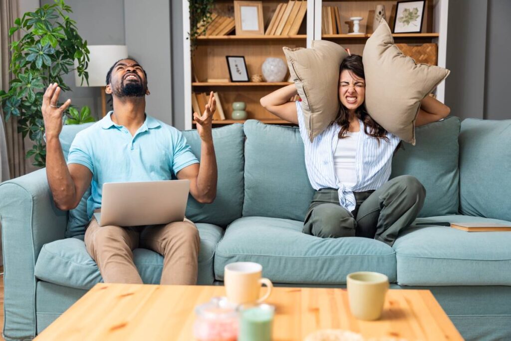 Imagem de um casal em uma situação de desconforto devido ao ruído, simbolizando a aplicação da Lei do Ruído para garantir o bem-estar nas áreas residenciais e minimizar a poluição sonora.