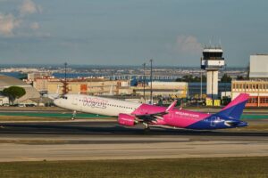 Imagem de um avião da Wizz Air decolando, simbolizando a saída definitiva de Portugal, um passo importante para quem decide emigrar ou mudar-se permanentemente para outro país.
